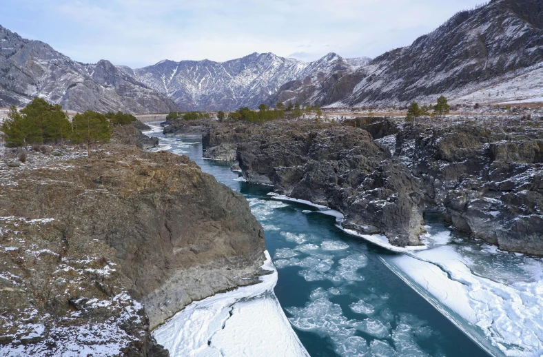 a river runs between a mountain range and a valley