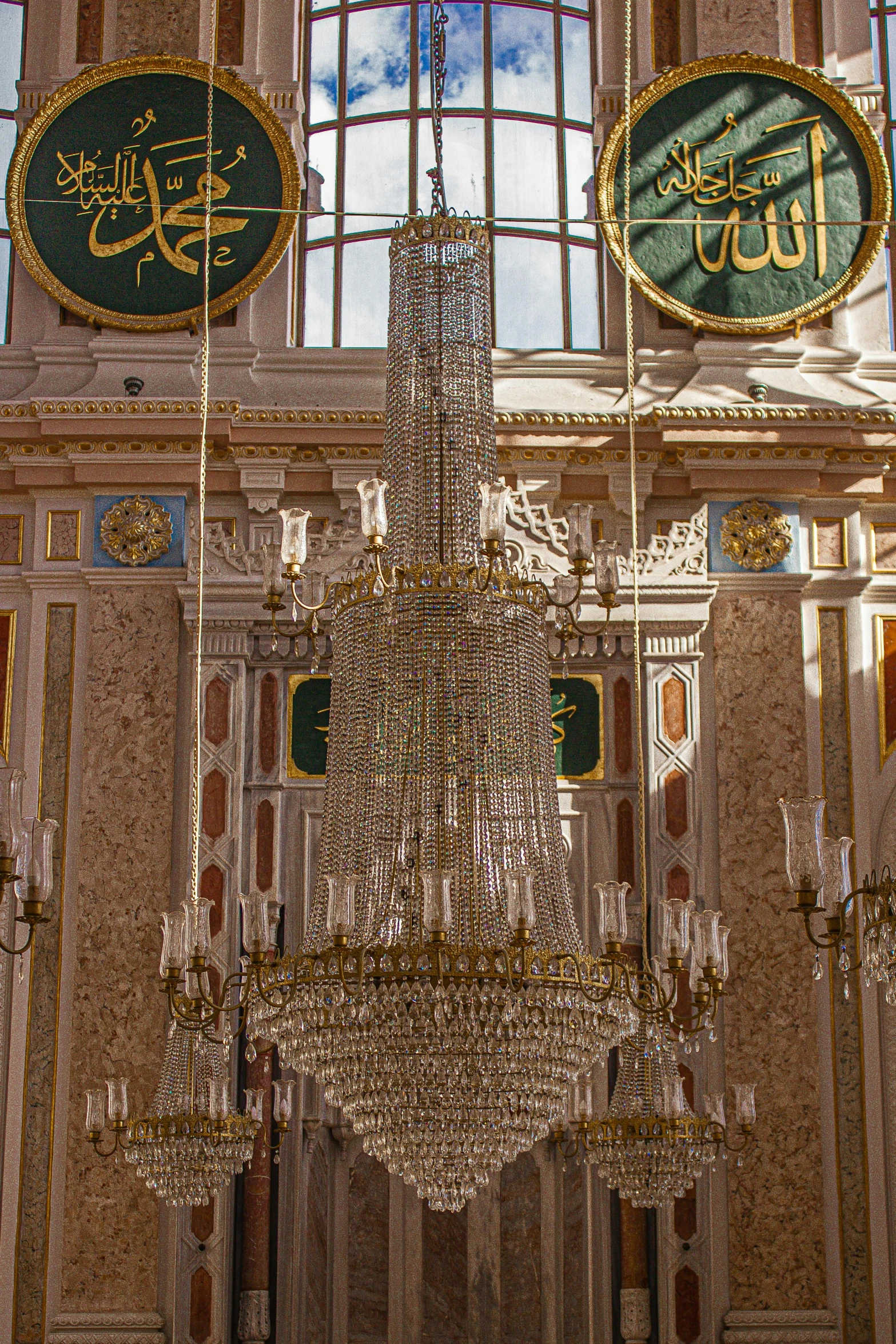 a large chandelier hanging from the ceiling in front of a window