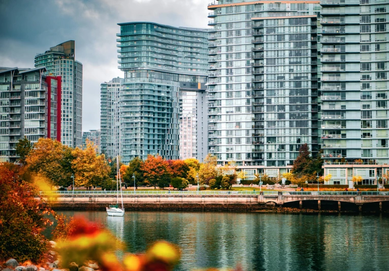 tall apartment buildings along the water next to a bridge