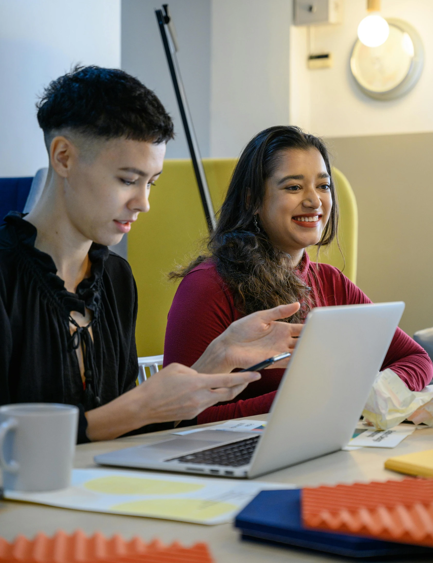 two people are looking at their laptops in a meeting