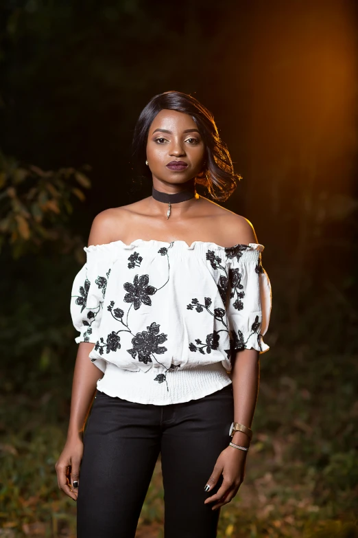 a woman with a white top stands in the woods