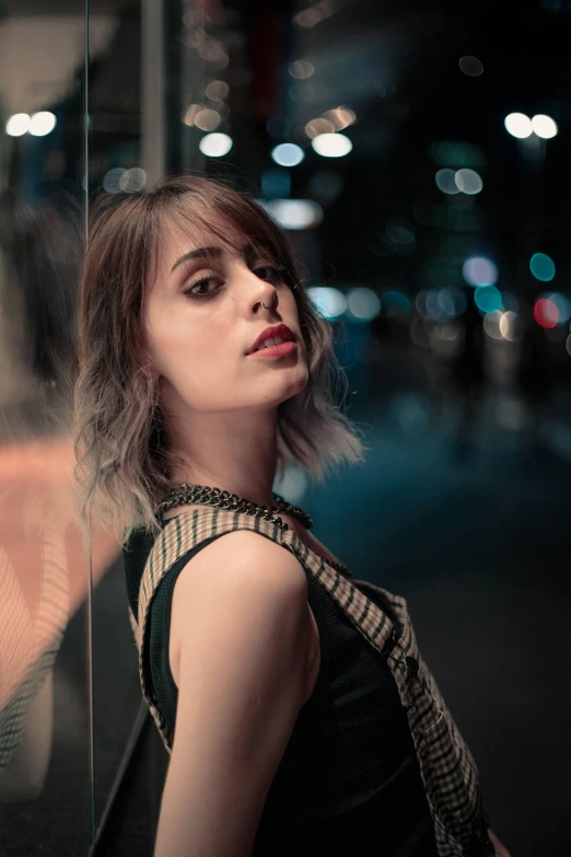 a woman is standing next to the window with a tie on