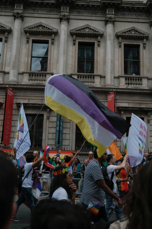 some people are holding a rainbow flag and banners