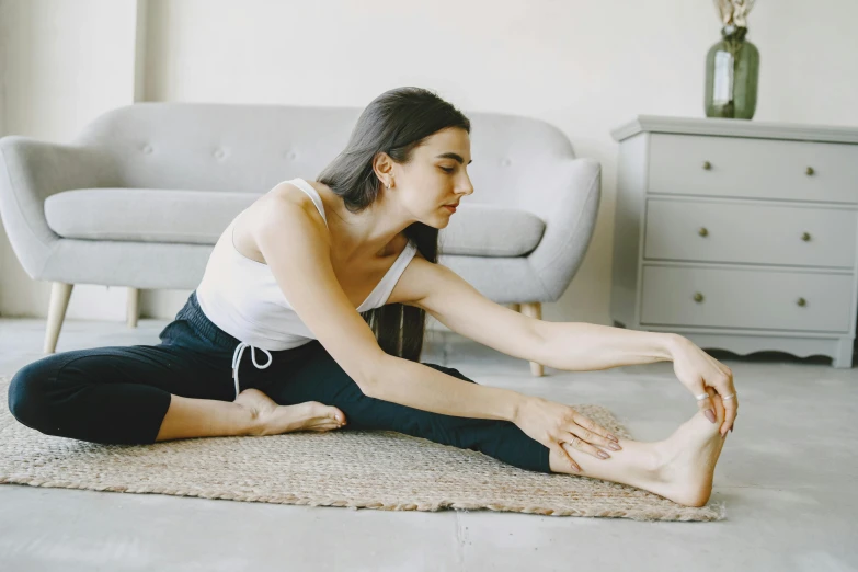 a woman doing stretching exercises in a white room