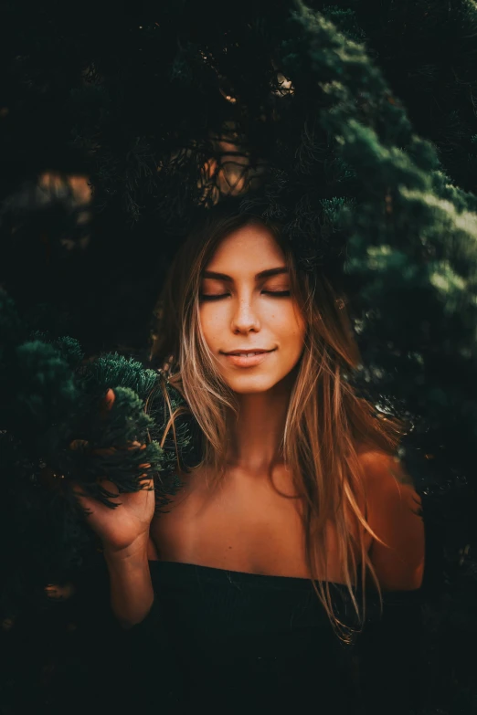 a woman with blonde hair holding some bushes