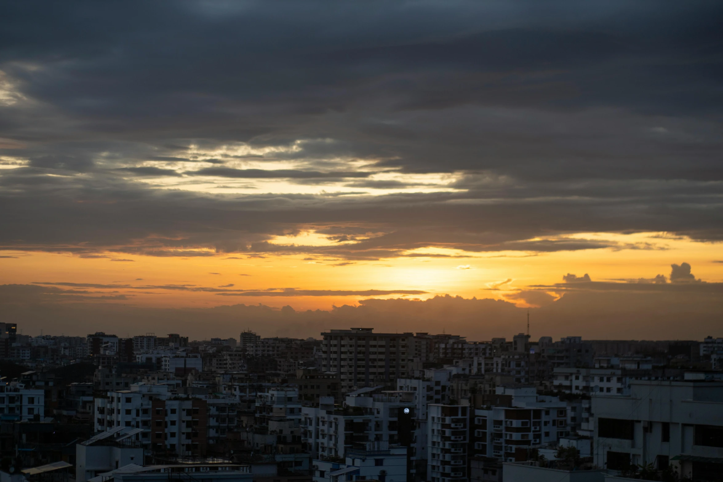 a skyline at sunset with the sun setting over the city