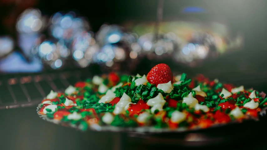 a red strawberry on top of a decorated cake