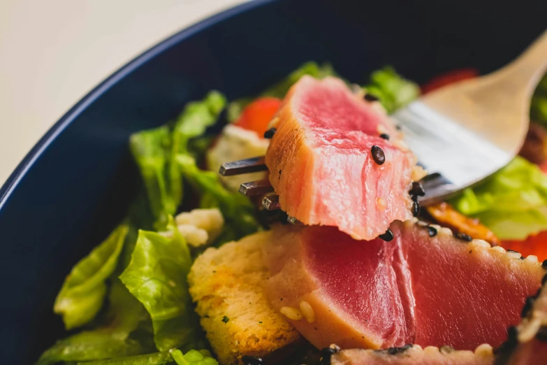 a salad with lettuce, tomatoes, fish and cauliflower