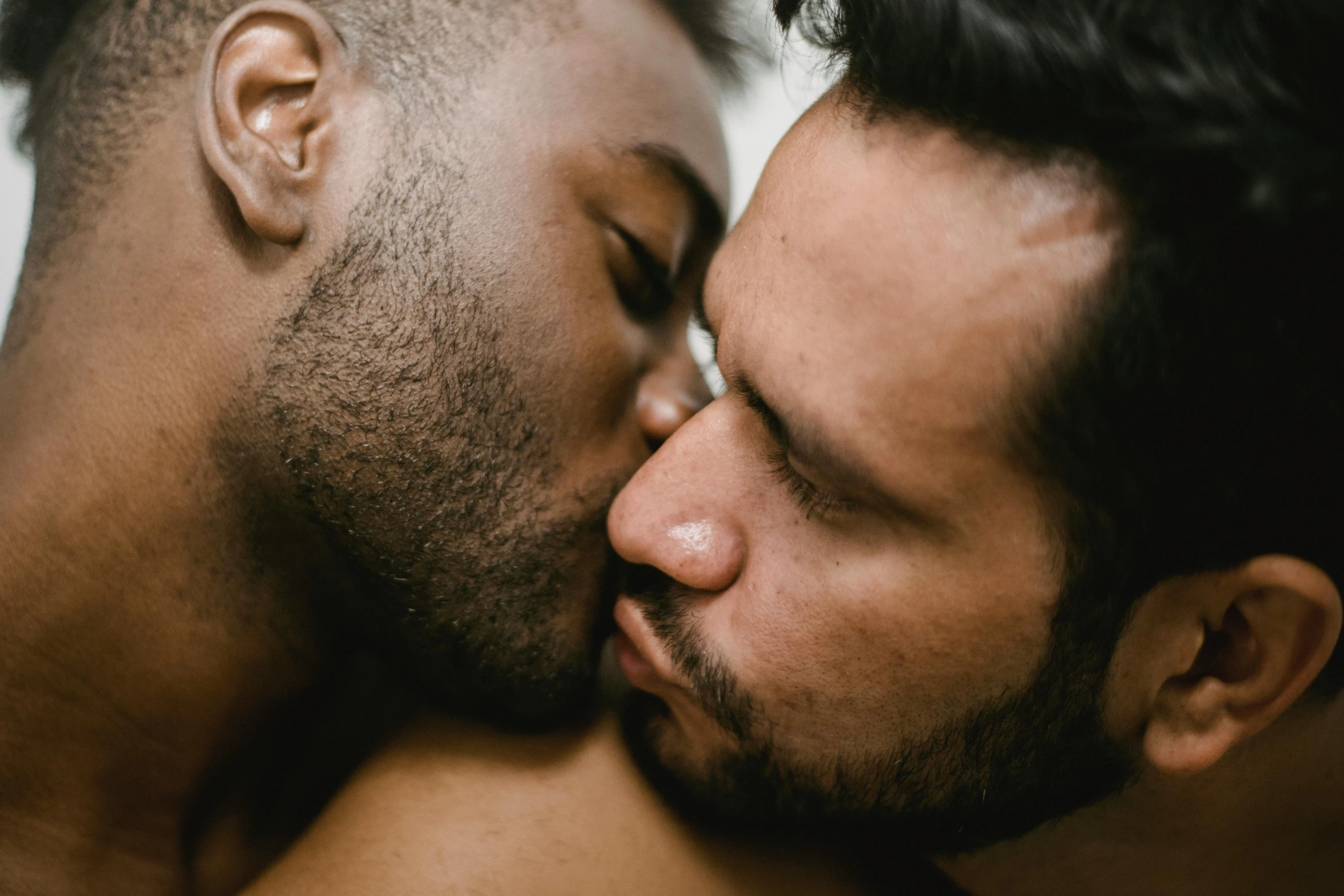 two men close to one another while they kiss