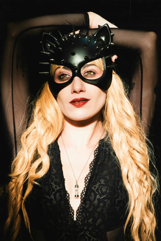 woman wearing cat mask with blonde hair and large necklace