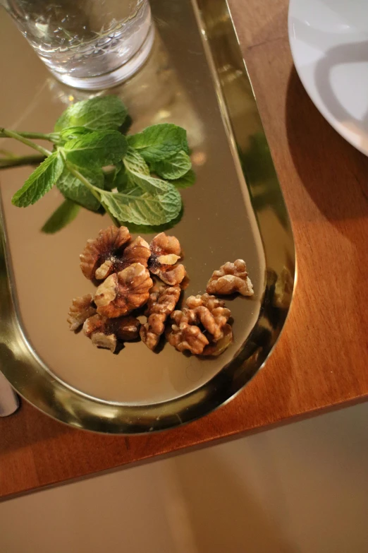 some leafy mint and walnuts sit on a tray