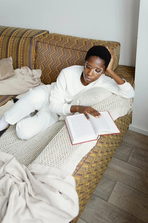 woman lying on the sofa reading a book