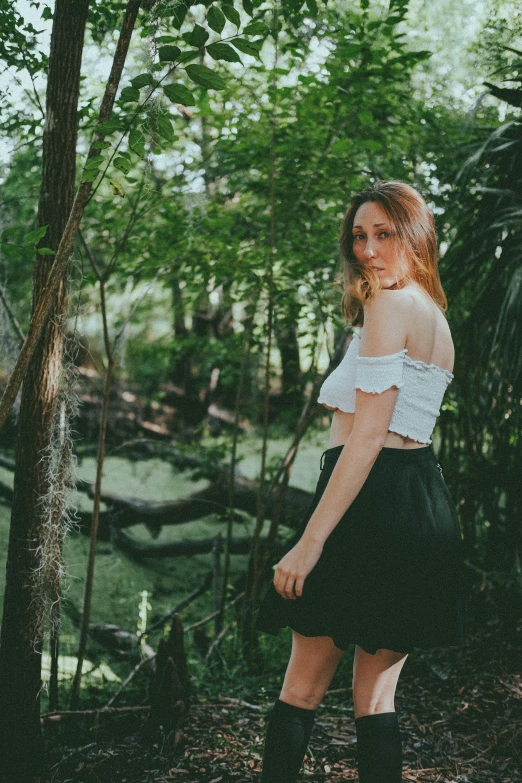 a girl standing on a rock and wearing boots