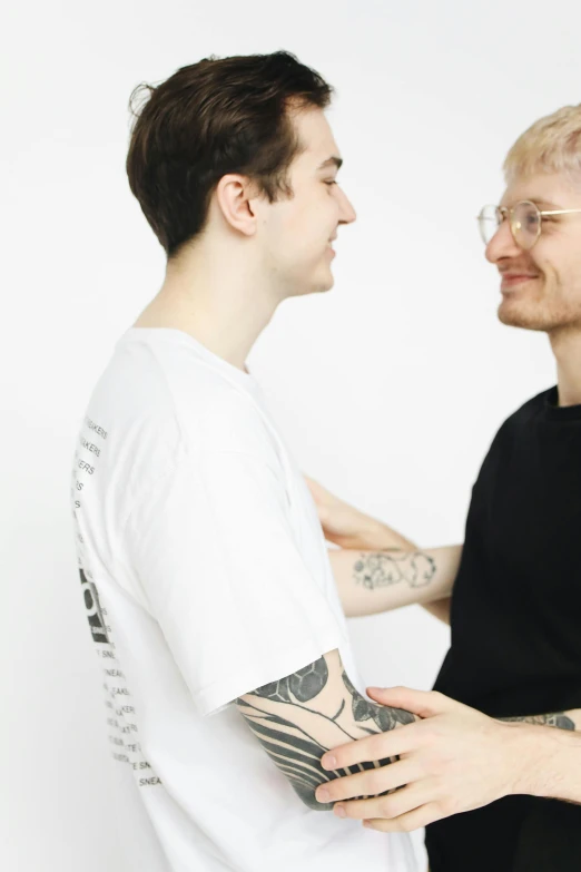 two young men, one wearing glasses and the other wearing a white shirt