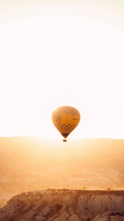 the balloon is being flown above the mountain side