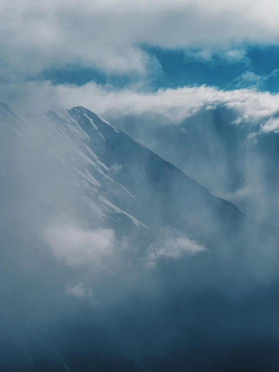 a bird flies among clouds in a mountains landscape