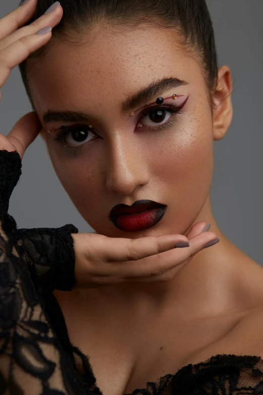 a woman with black makeup posing for a picture