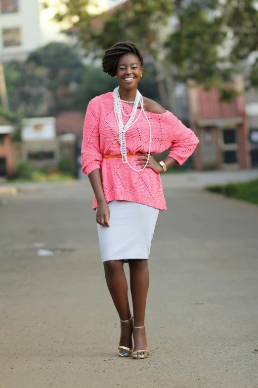 young african woman standing on side walk smiling