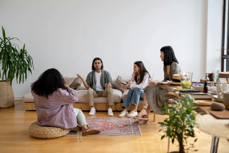 five friends in a living room sitting down and talking