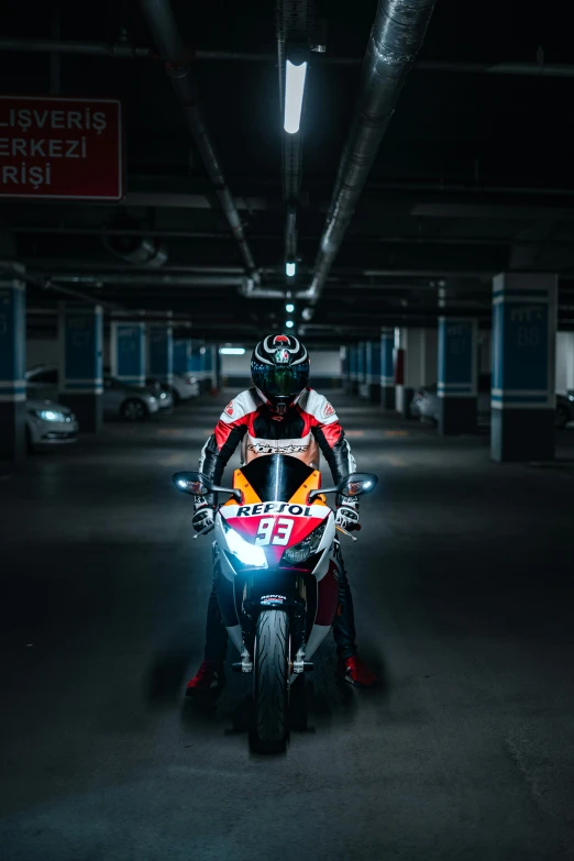 a man in black helmet riding red and white motorcycle