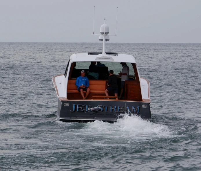 four men are riding in the back of a boat