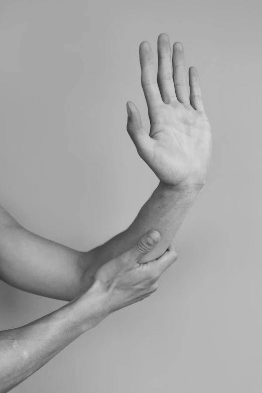 two hands reaching up towards each other with the wrist raised