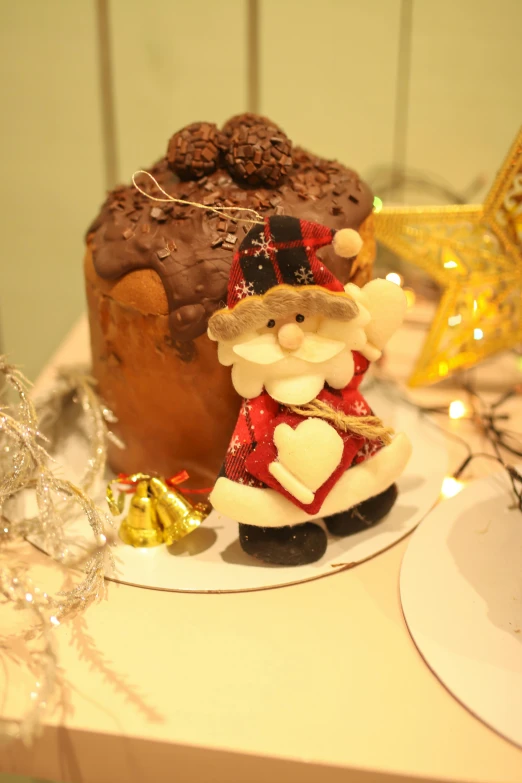 a small cake on a plate with santa claus figurine next to it