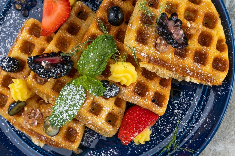 a plate that has waffles with fruit on it