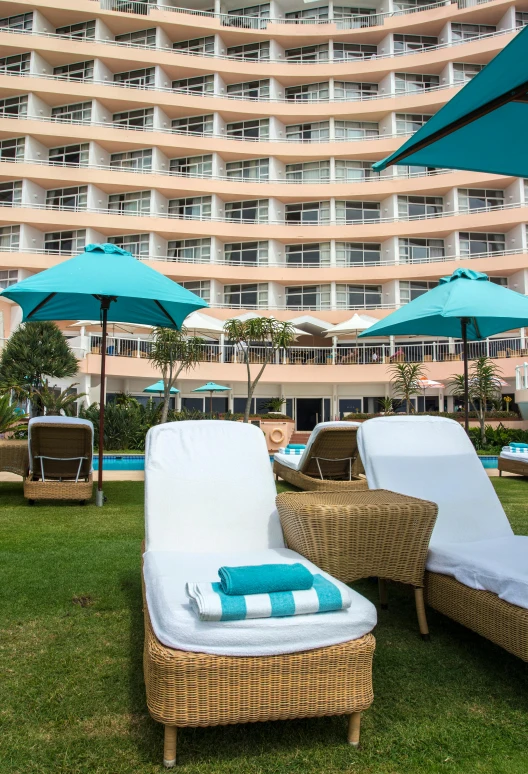 an open el sitting with lawn chairs and blue umbrellas