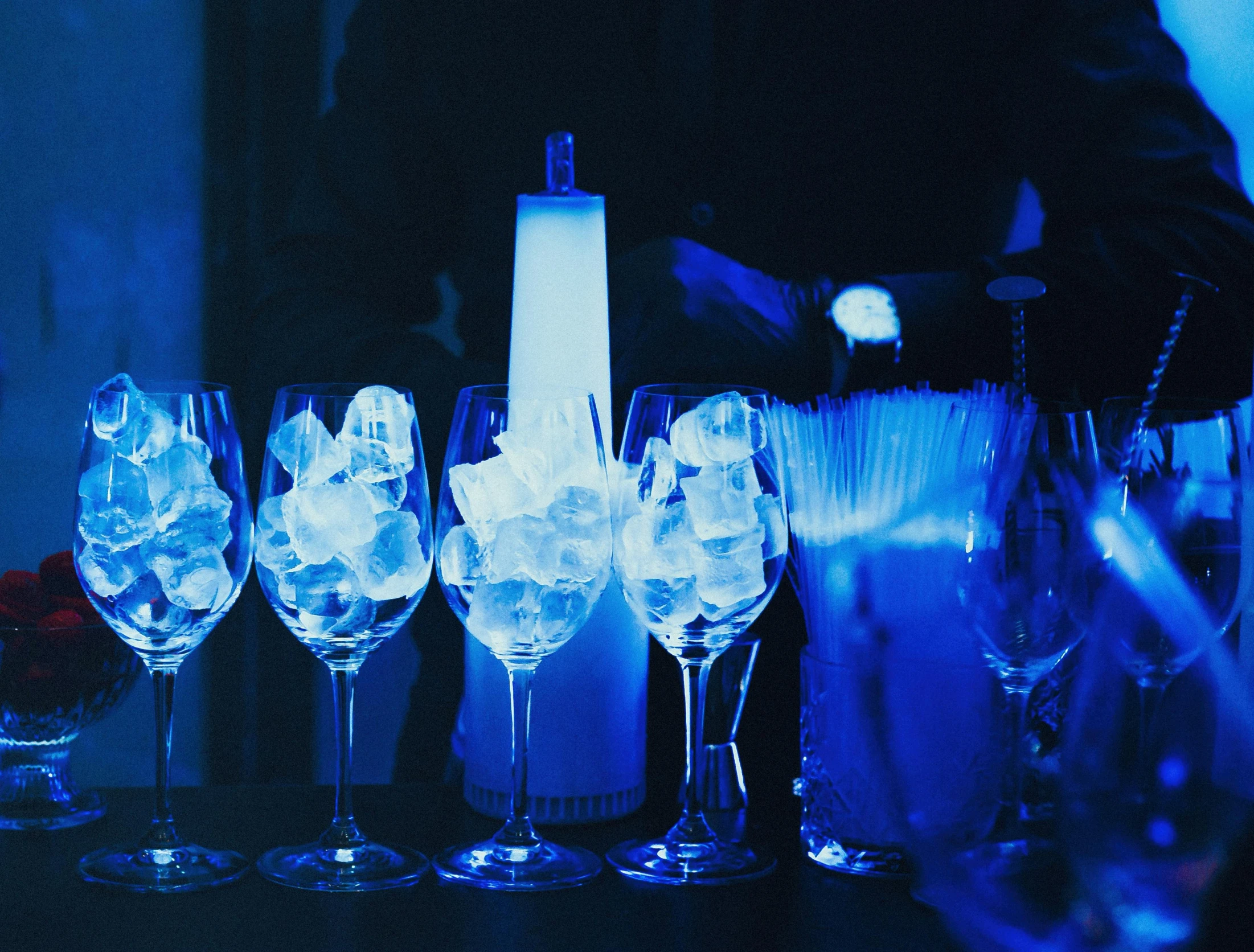 glasses are lined up on a table with ice