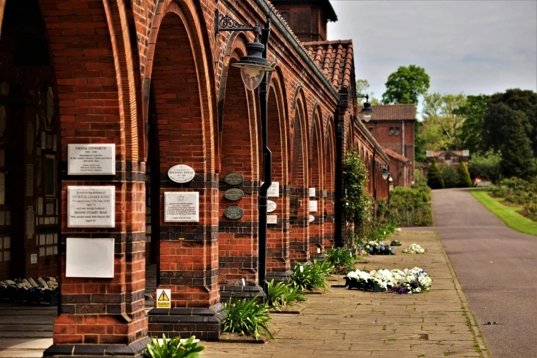 a large brick building with many flowers in the garden