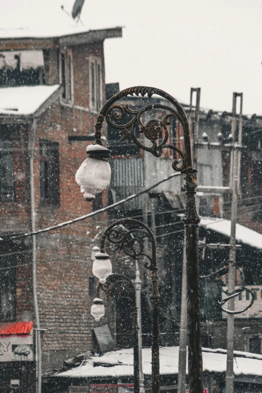 a street light with snow falling on it