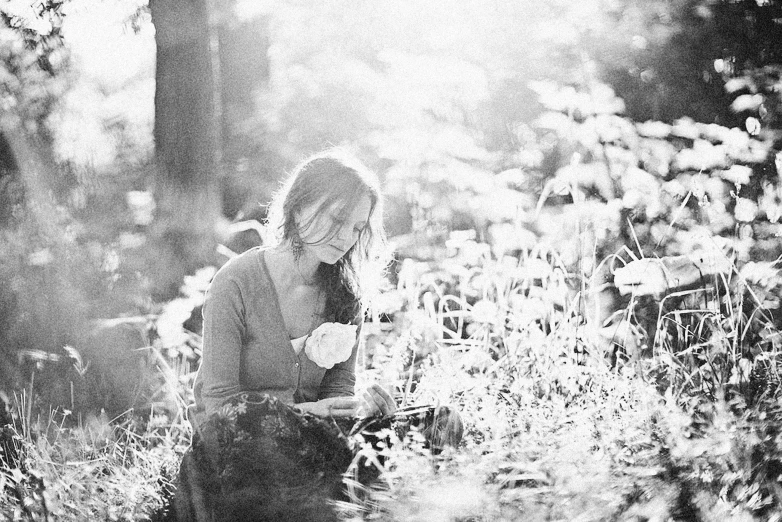 a woman walking through a forest with a cat