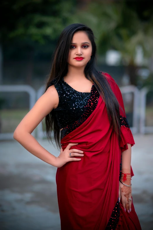 woman with large  in traditional dress, dressed up in maroon, posing for a pograph