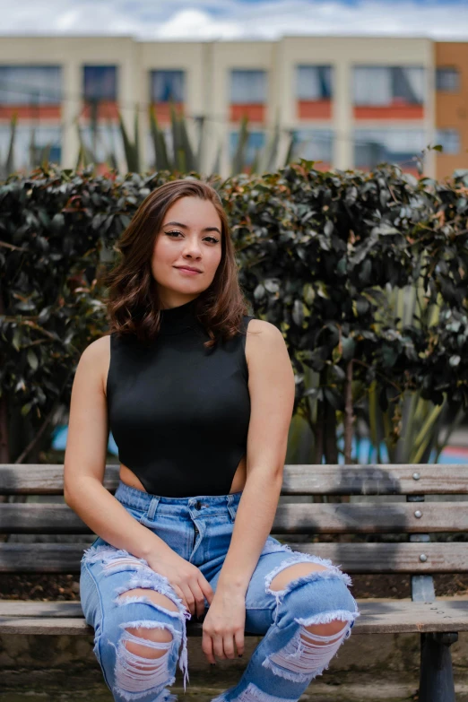 a beautiful young woman sitting on top of a wooden bench