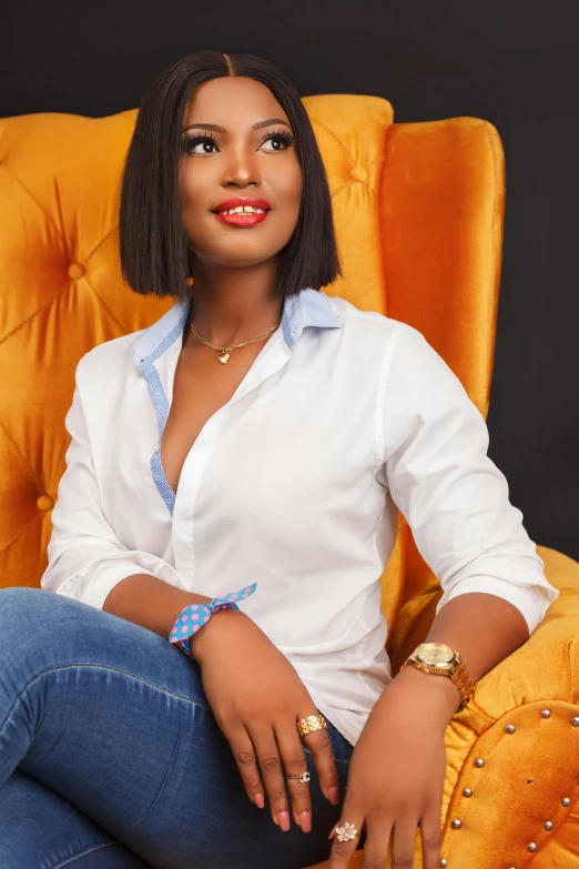 a woman sitting in an orange chair with a gold watch