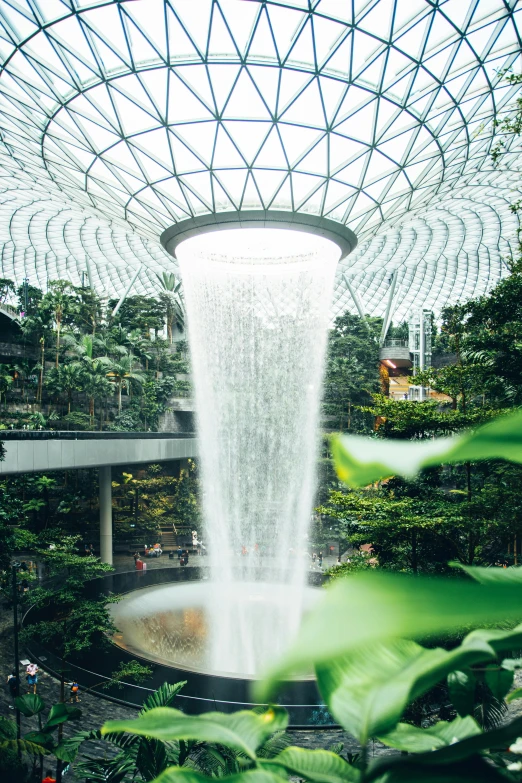 there is a building that has a glass roof with a waterfall inside it