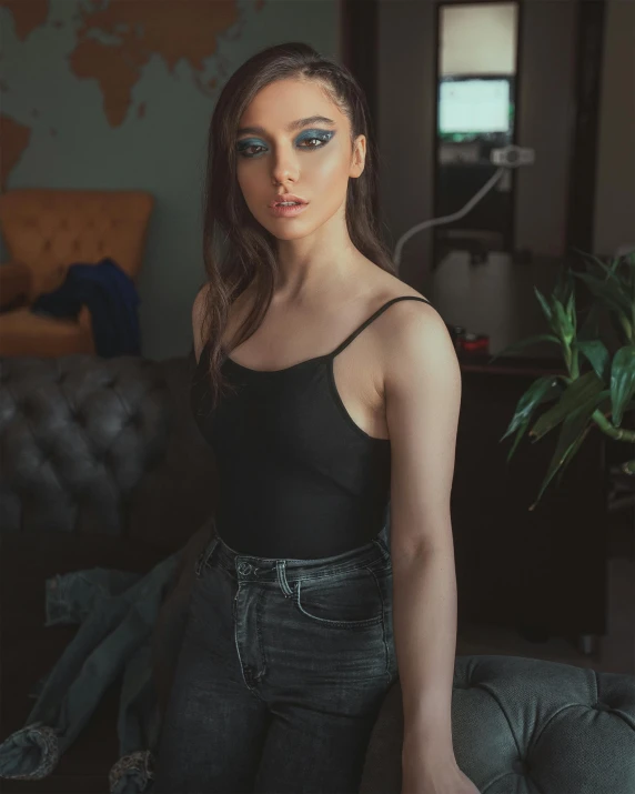 a woman in black shirt standing near couch