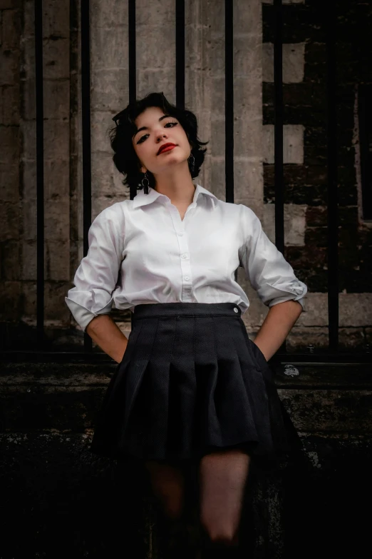 a woman standing next to a black fence