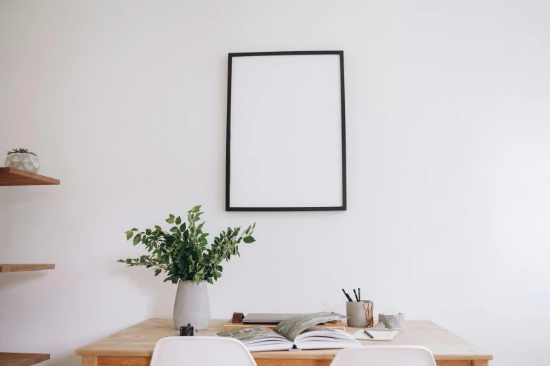 a wooden table with two chairs sitting in front of a white wall