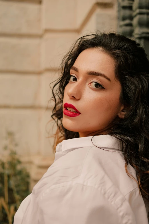 a woman in a white shirt posing with her hair up