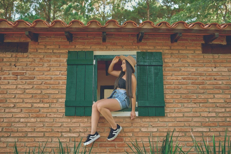 a woman in a bikini top and shorts jumps out a window