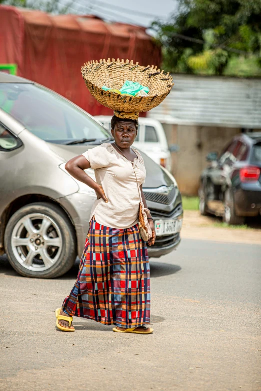 woman carrying baskets on her head as she walks down the street