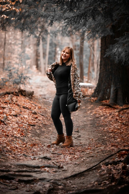 there is a woman standing in the middle of leaves and trees