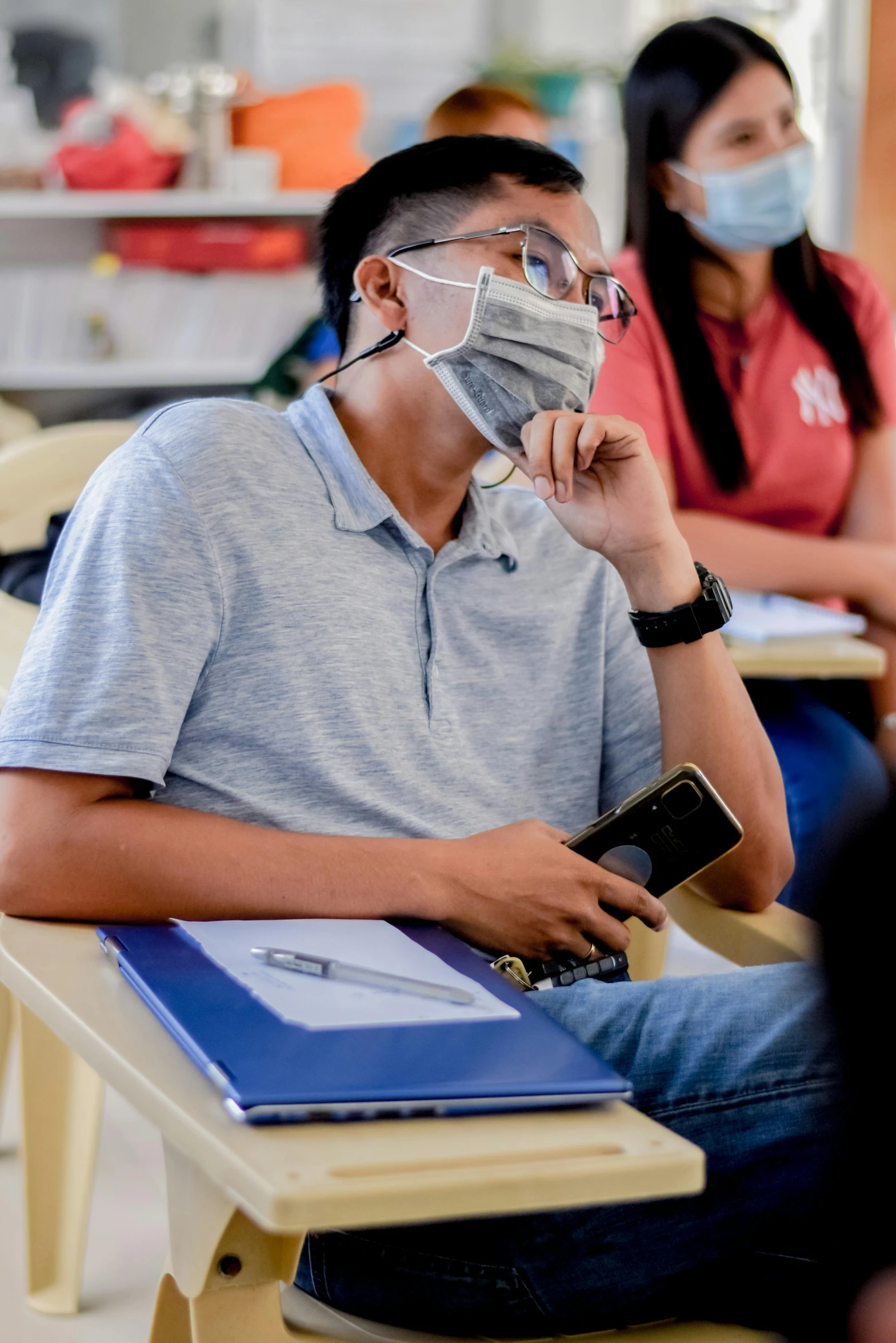 two students in class wearing protective face masks