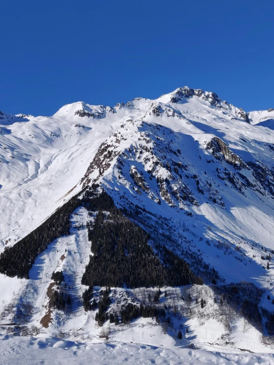 a person in skis is standing on the edge of a snow mountain