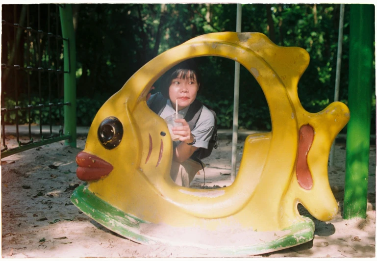 a  standing in front of a fish shaped structure