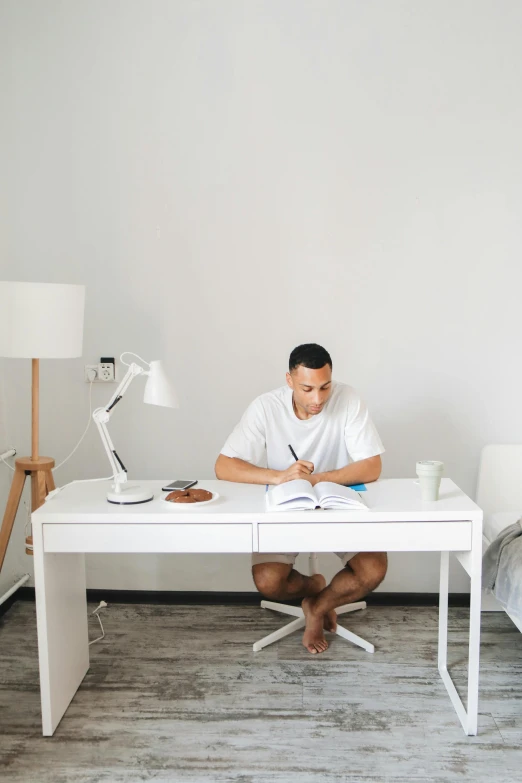 a man in a white shirt is sitting at a desk