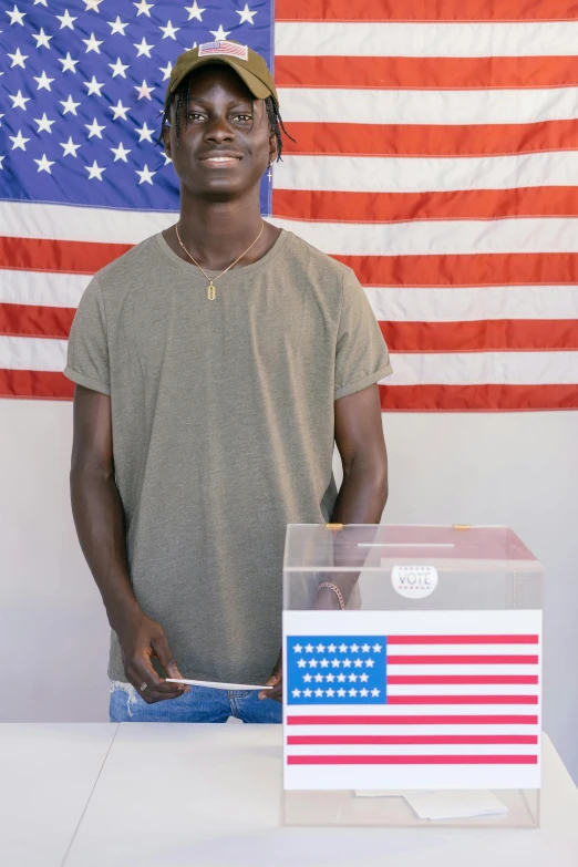 a person standing next to a box with an american flag behind it