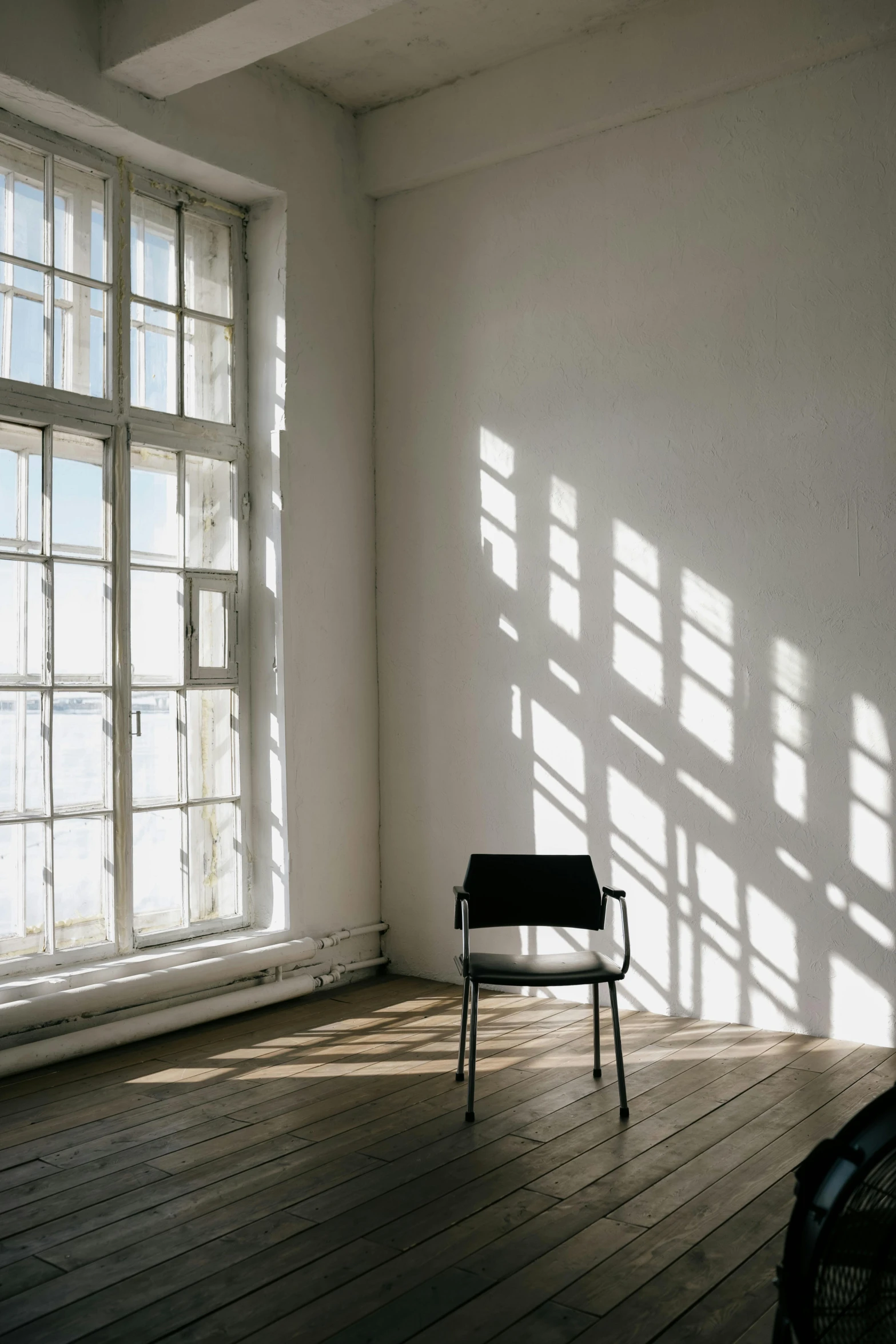 an empty chair sits in a large room with several windows